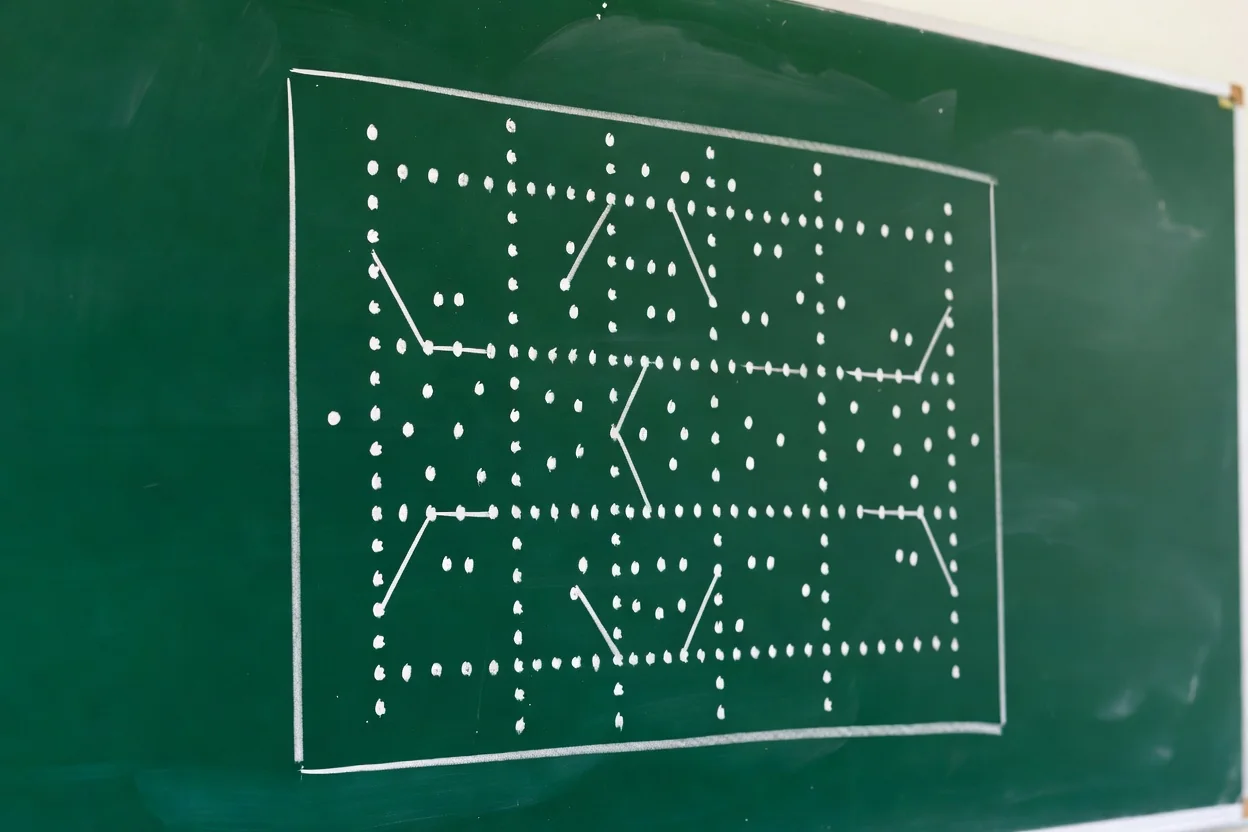 A green chalkboard covered only in white dots and connecting lines forming a formation diagram